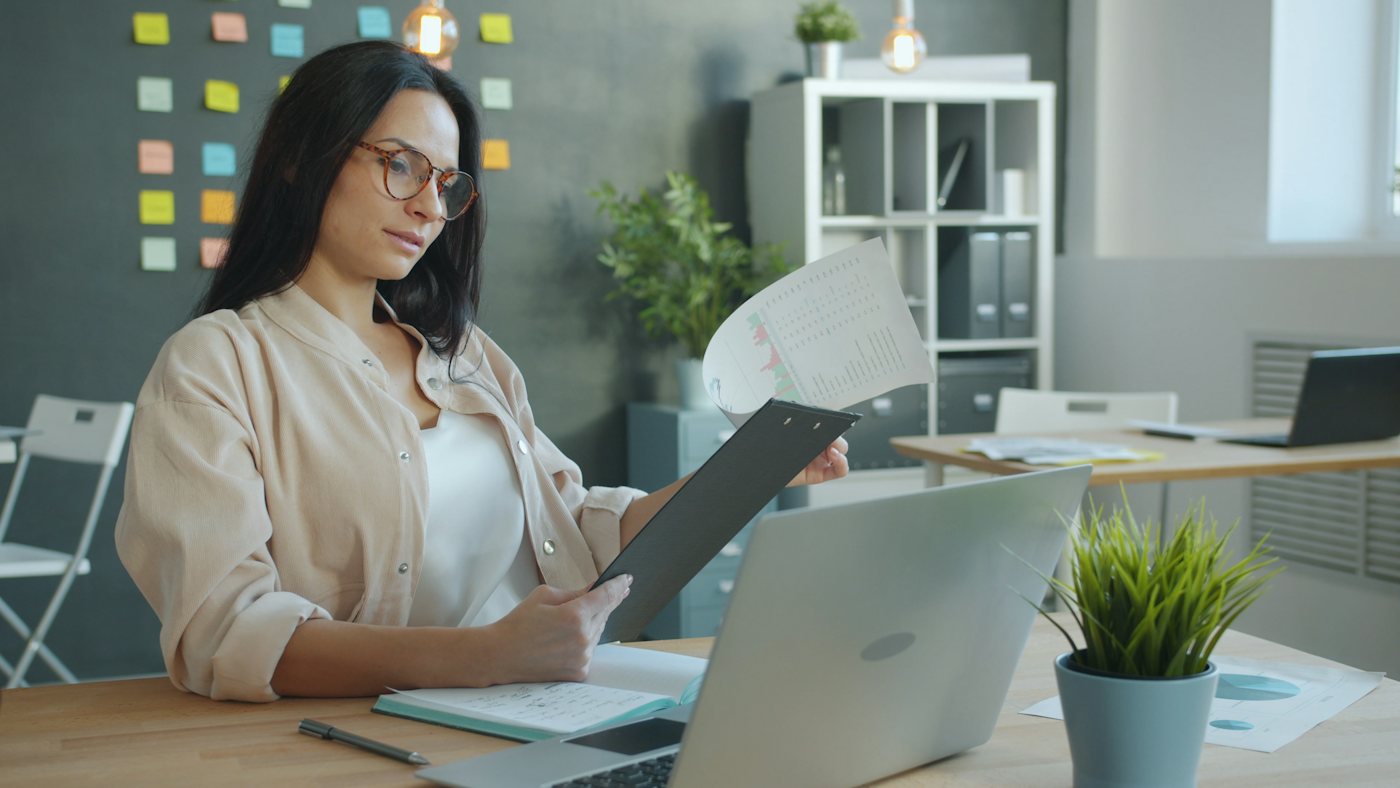 A director reviewing papers at her desk